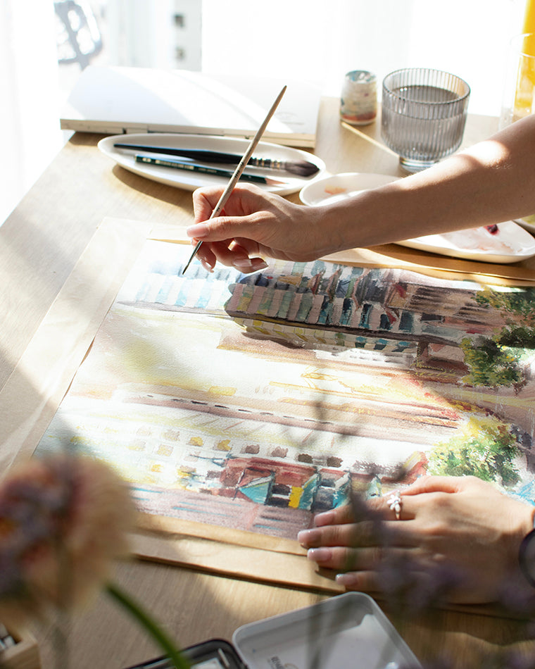 Artist creating custom travel illustration with watercolor paints
